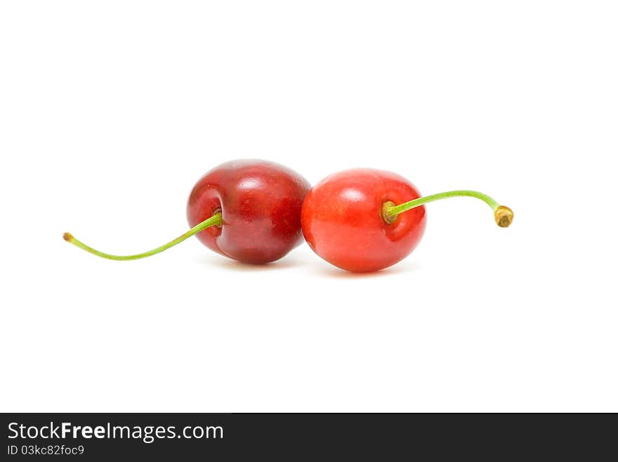 Two ripe cherries on a white background closeup. Two ripe cherries on a white background closeup