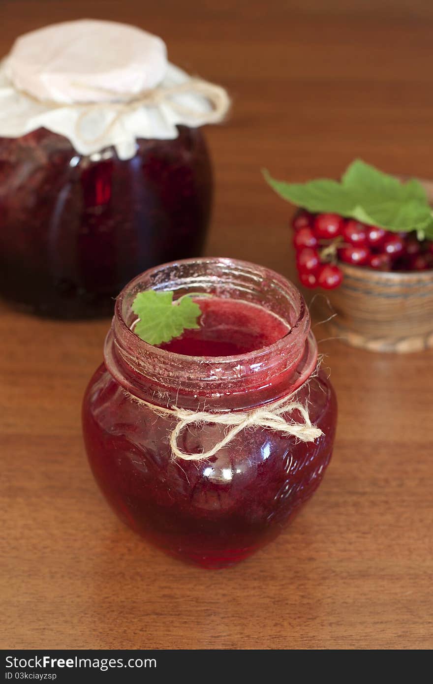 Glass pots of currant jam over wooden table. Glass pots of currant jam over wooden table