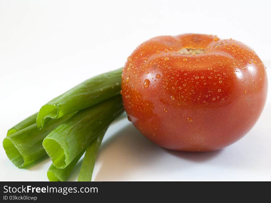 Green onions and tomato isolated on white background