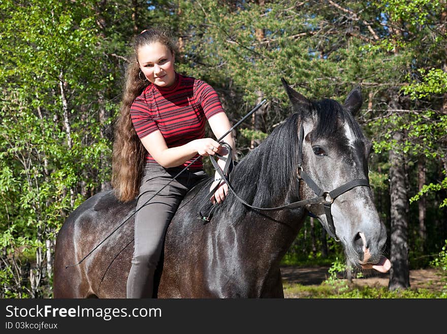 Beautiful girl on a black horse in a forest. Beautiful girl on a black horse in a forest