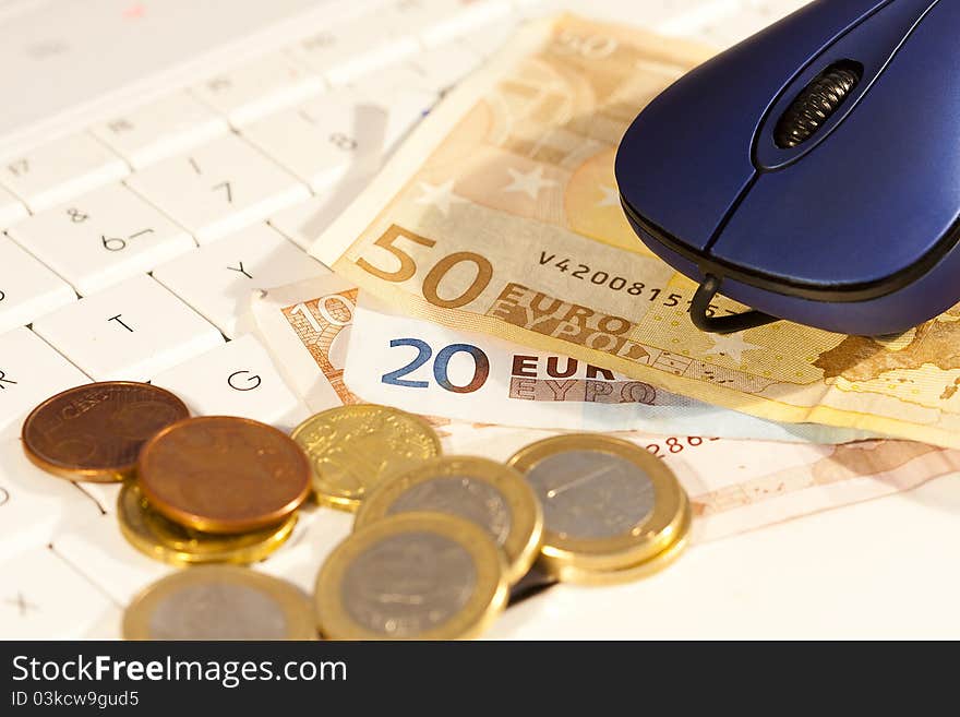 Euro coins and notes on the computer keyboard. Euro coins and notes on the computer keyboard