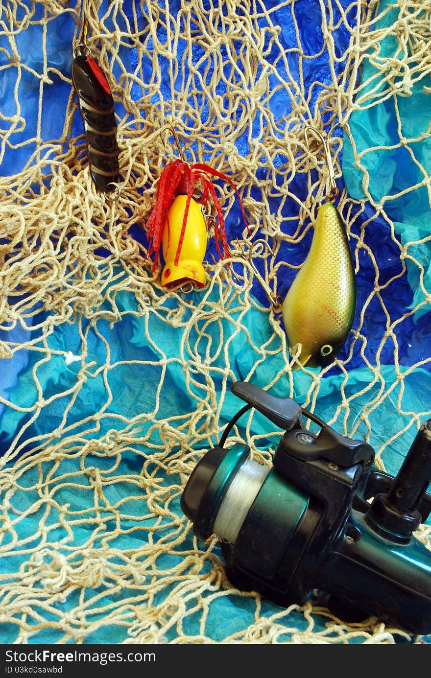 Fishing net, reel and lures on blue and aqua background. Fishing net, reel and lures on blue and aqua background