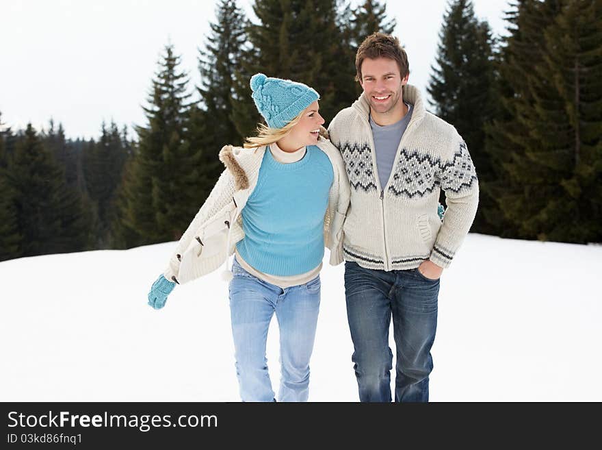 Young Couple In Alpine Snow Scene laughing