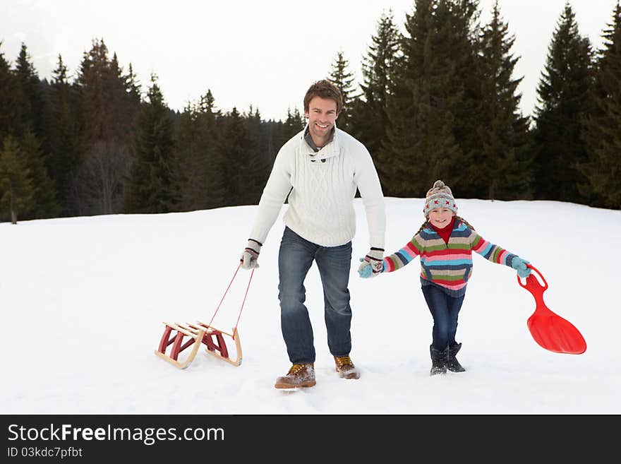 Young Father And Daughter Walking In Snow