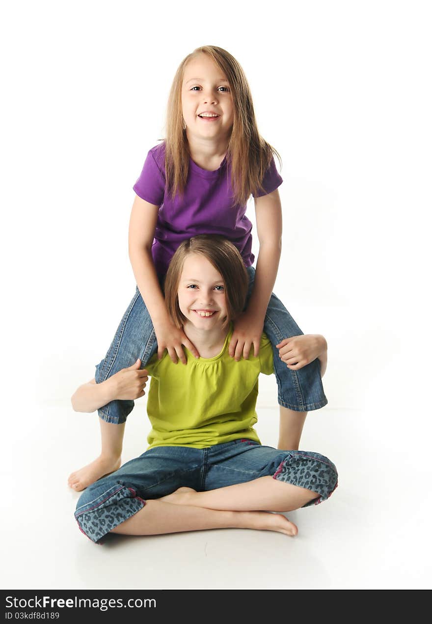 Cute young sisters isolated on white in studio. Cute young sisters isolated on white in studio