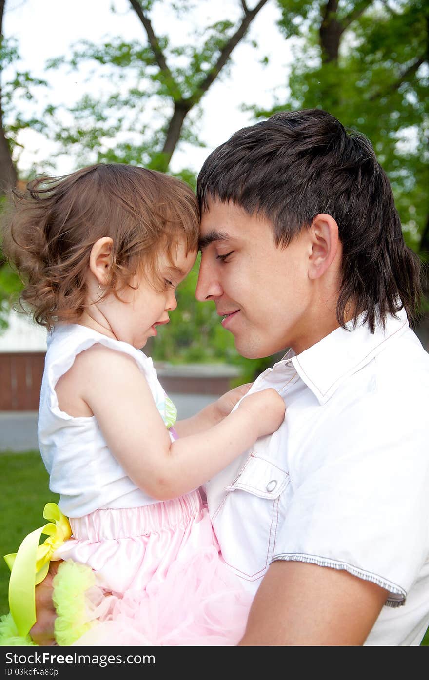 The father and the daughter together lay on a grass