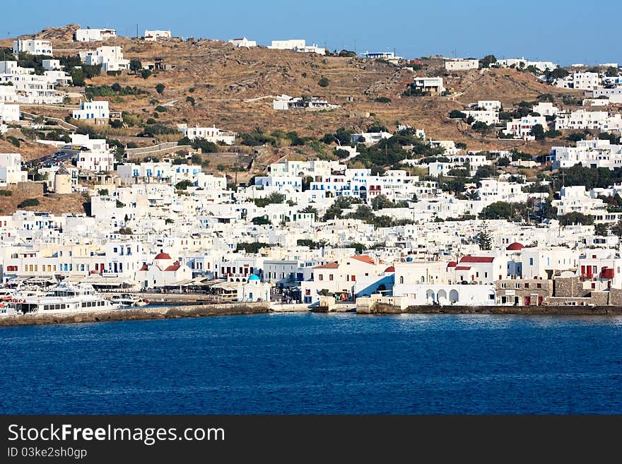 The coastline of greek island of mykonos with all the white washed houses clinging to the water. The coastline of greek island of mykonos with all the white washed houses clinging to the water