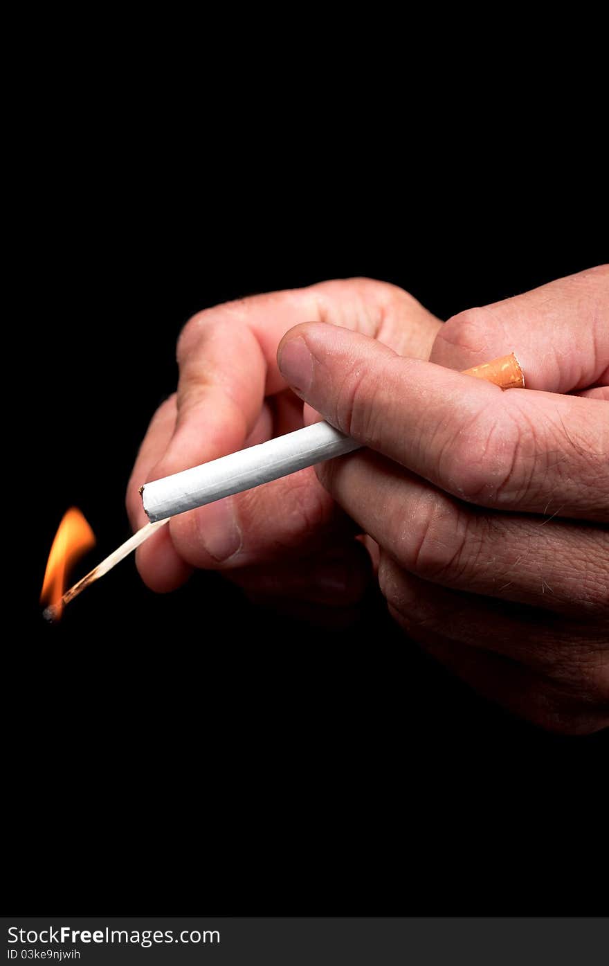 Men s hand lights a cigarette