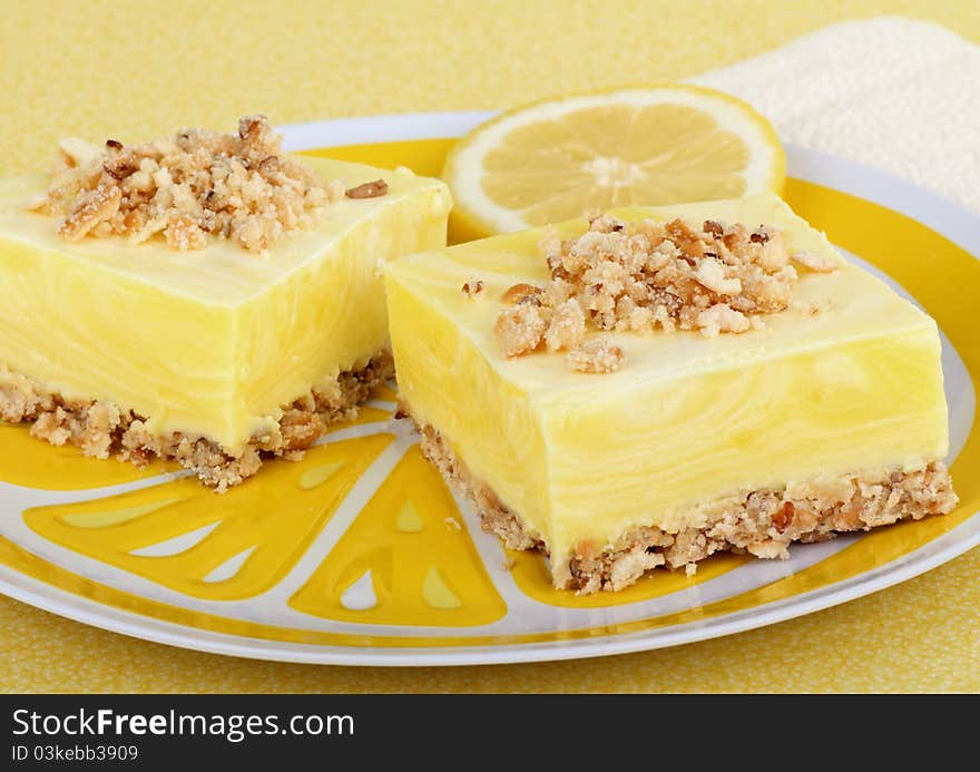 Two lemon square with a lemon slice on a plate. Two lemon square with a lemon slice on a plate