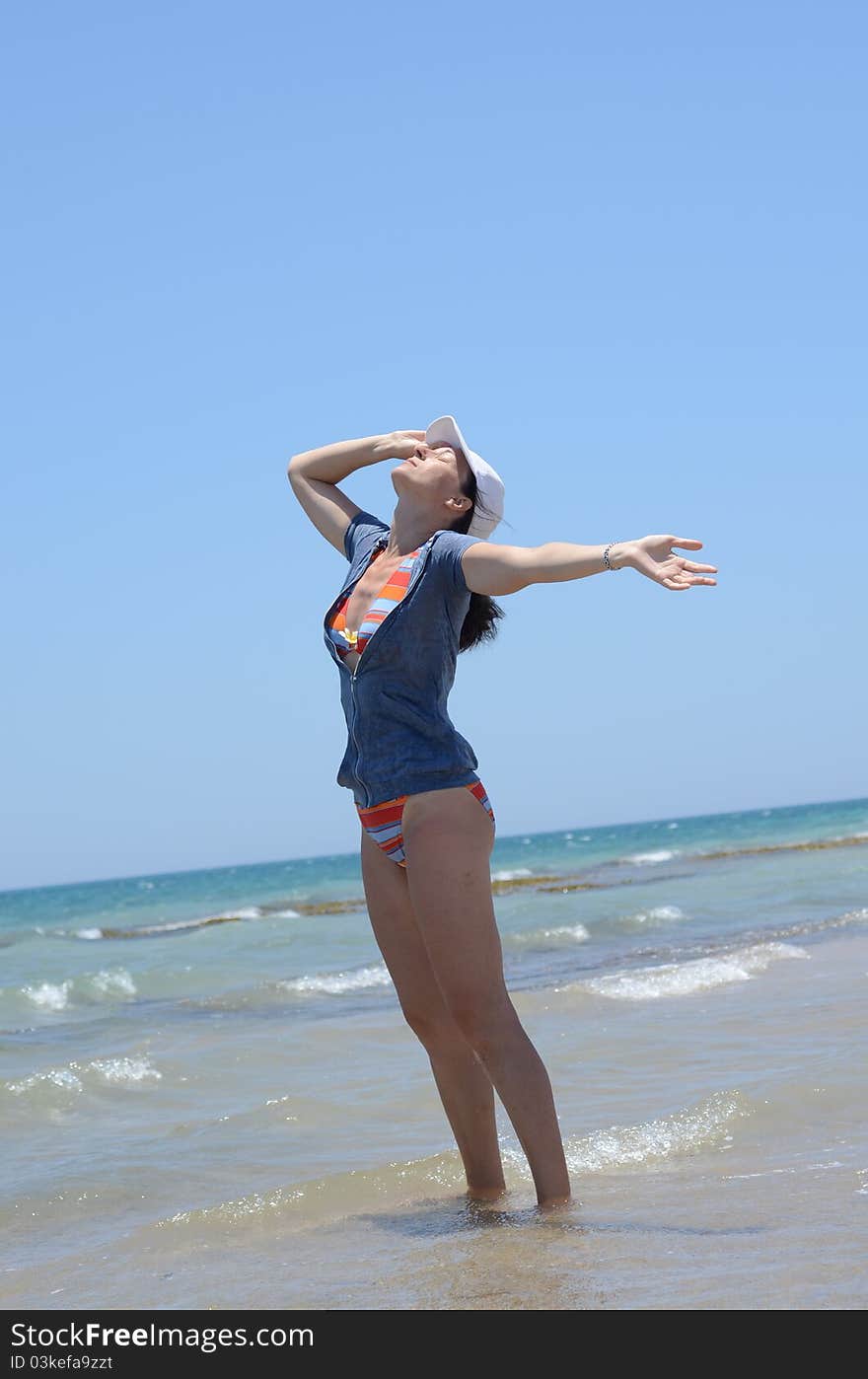 Beautiful Young Woman Relaxing By The Beach In