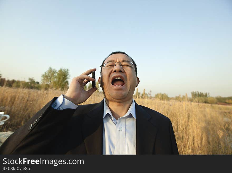 Asian businessman screaming on the phone.