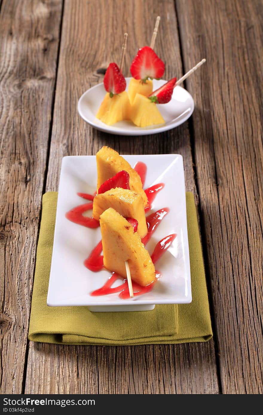 Pineapple and strawberry skewers garnished with sweet sauce. Pineapple and strawberry skewers garnished with sweet sauce