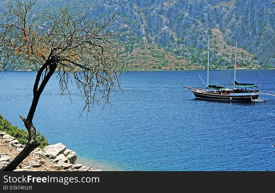 Sailboat at sea, on background rock. Sailboat at sea, on background rock