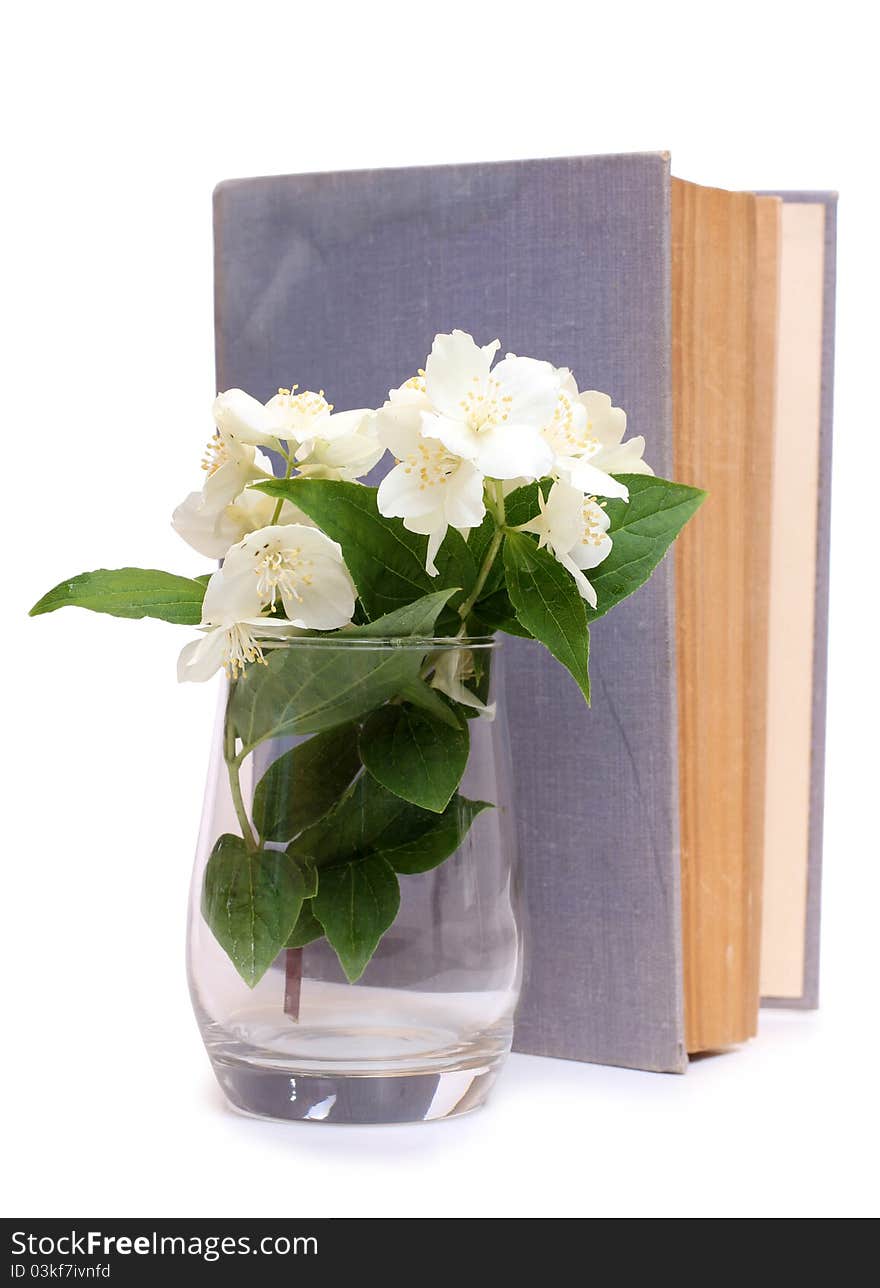 Color photo of an old book and a bouquet of jasmine