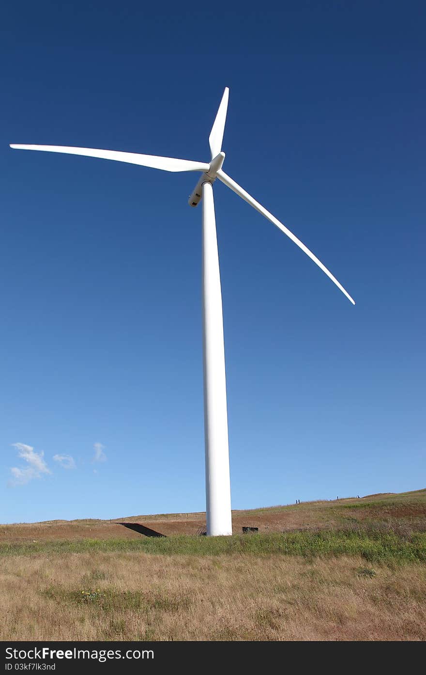 A wind turbine stands tall in a field. A wind turbine stands tall in a field.