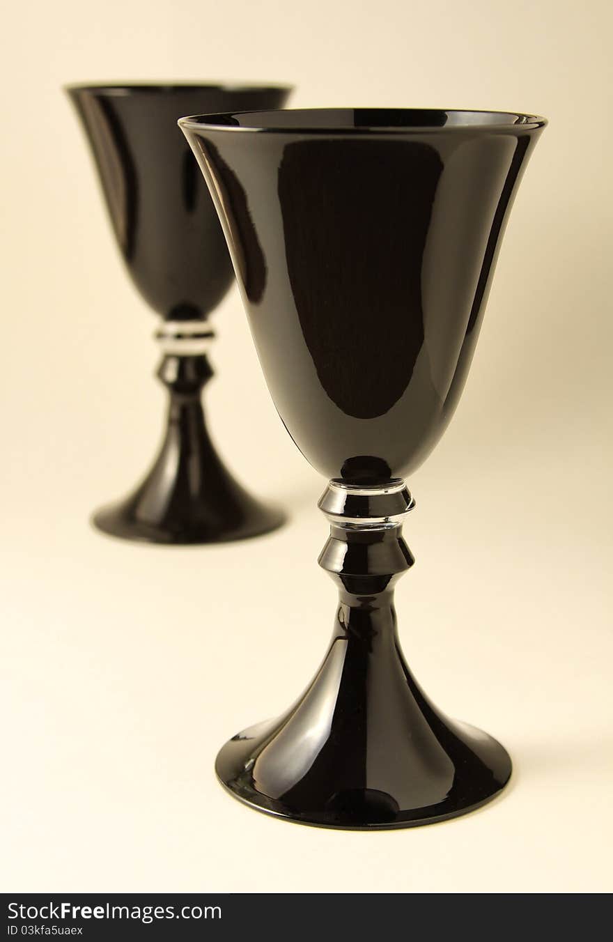 Two black wine goblets on a table. Two black wine goblets on a table