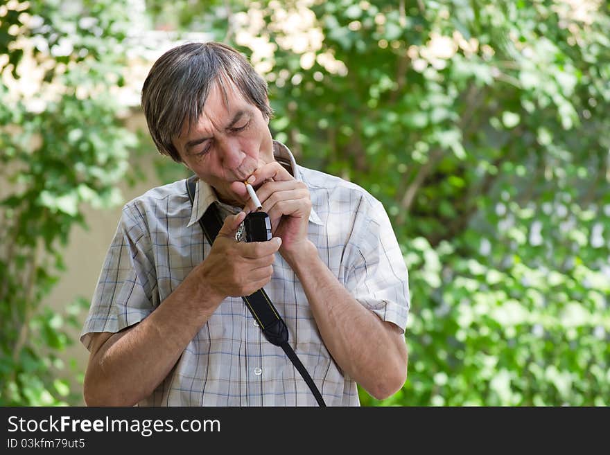 Man lighting a cigarette on the nature. Man lighting a cigarette on the nature.