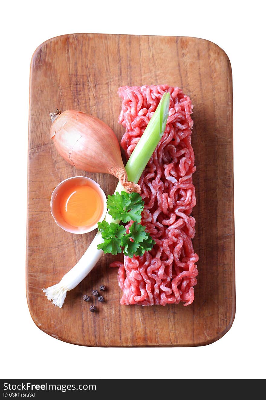 Raw minced meat and other ingredients - overhead, cut out on white