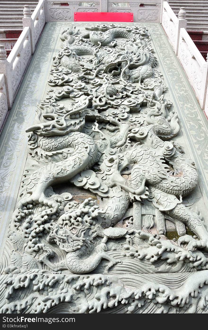 Typical Chinese carven dragon on wall expressing power and status in ancient thailand. Typical Chinese carven dragon on wall expressing power and status in ancient thailand