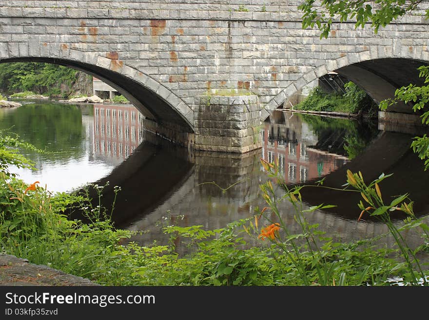 Bridge over river reflections flora