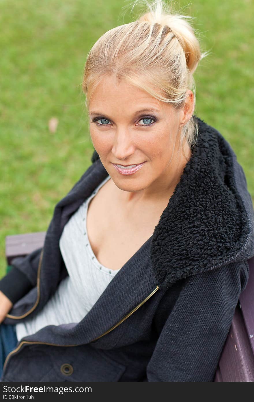 Young attractive woman relax in the park with her jacket on