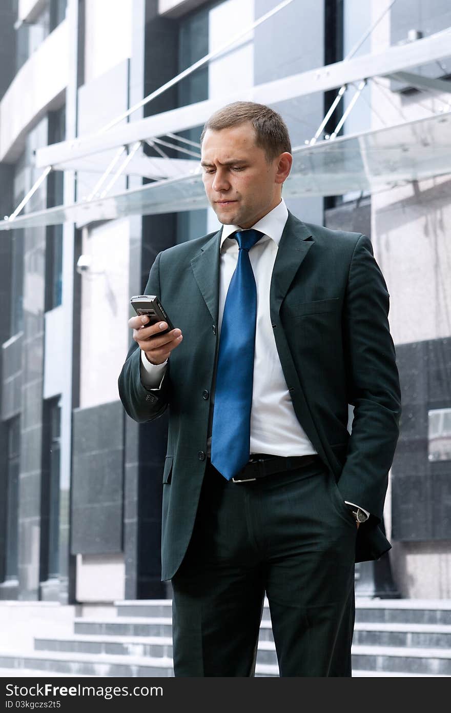 Young and successful businessman is reading a message on his smartphone