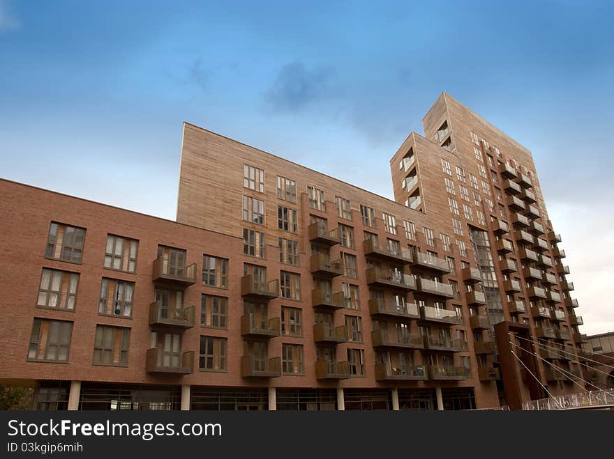 A Large Red Apartment Block under a blue summer sky