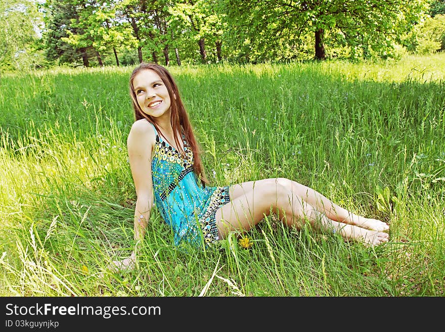 Young girl sits on the glade in the park. Young girl sits on the glade in the park