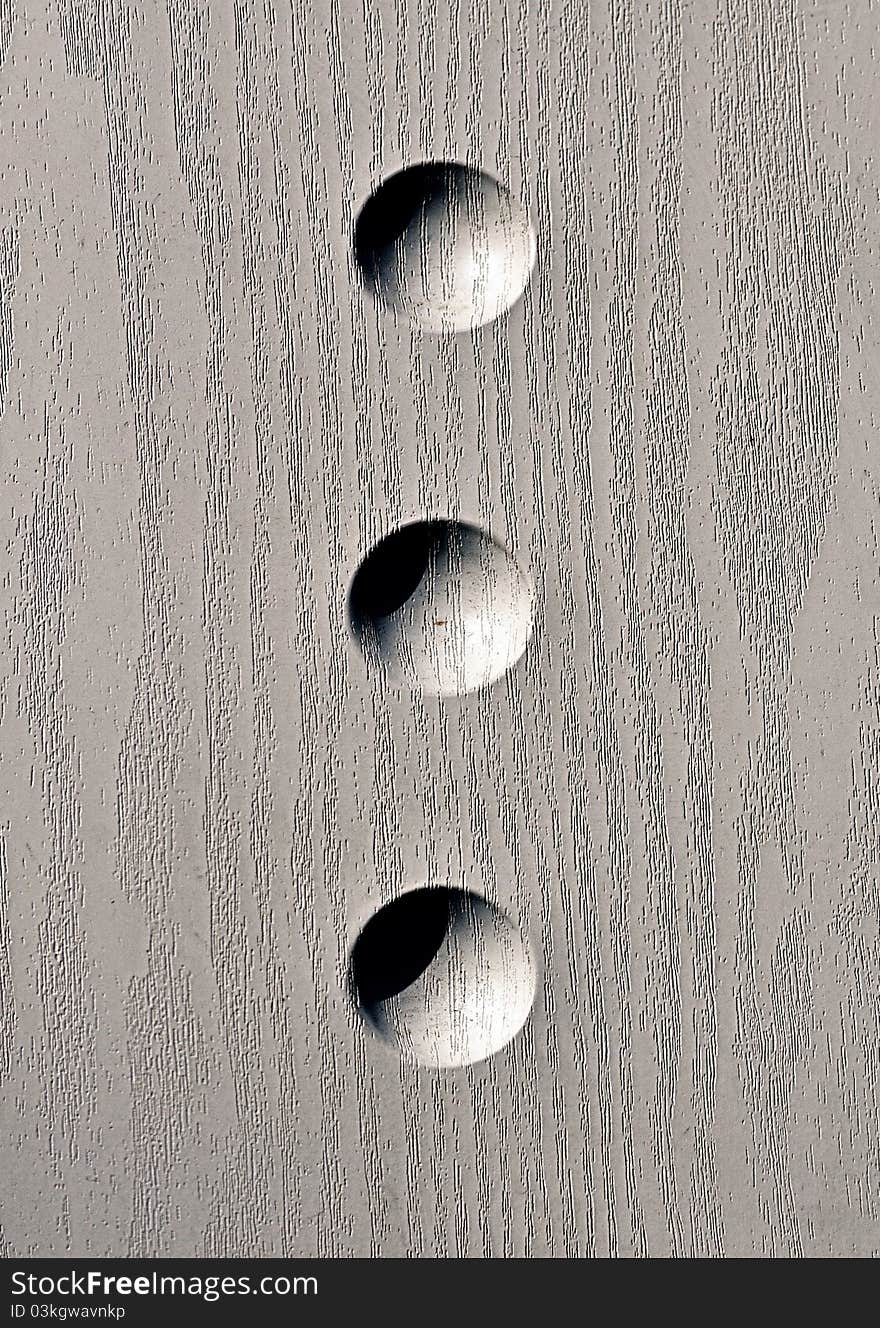 Three dots etched in wood