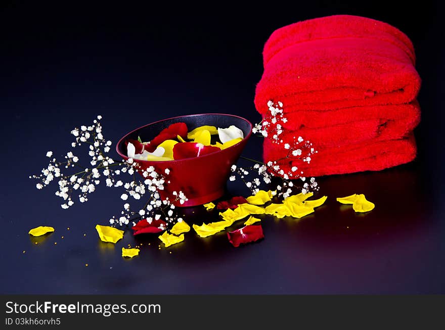 Red towels with flower and candle on black background. Red towels with flower and candle on black background