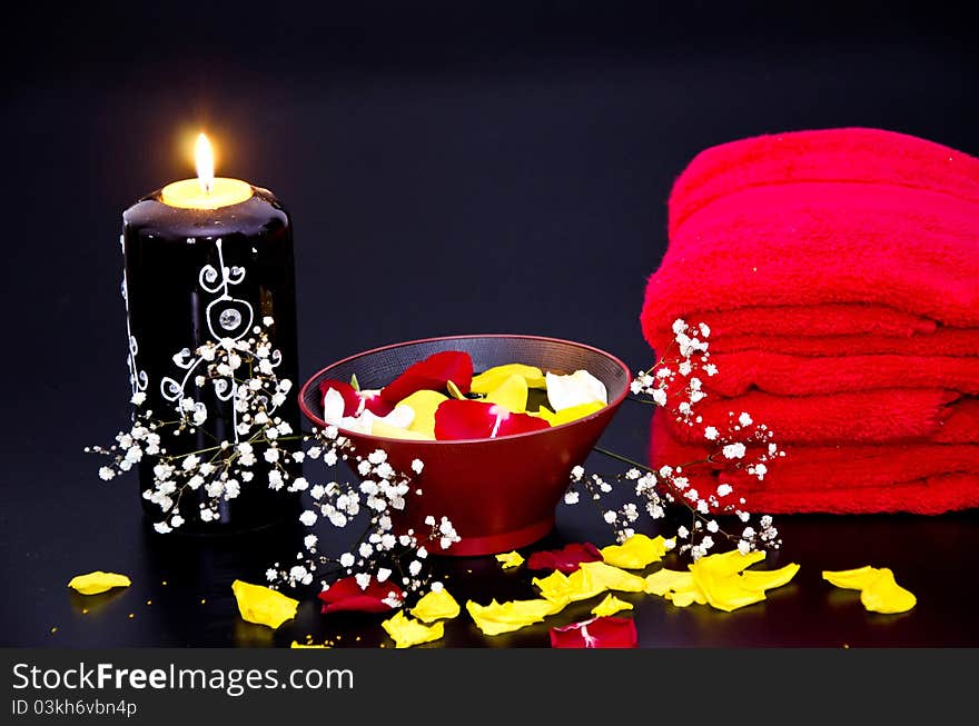 Red towels with flower and candle on black background. Red towels with flower and candle on black background