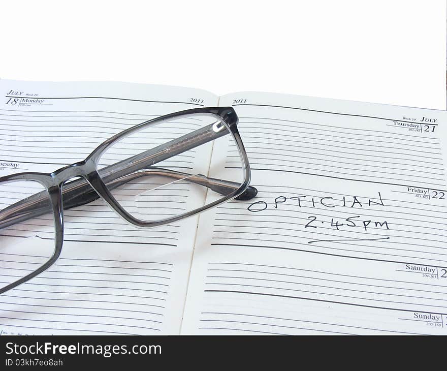 Spectacles on diary on white background. Spectacles on diary on white background