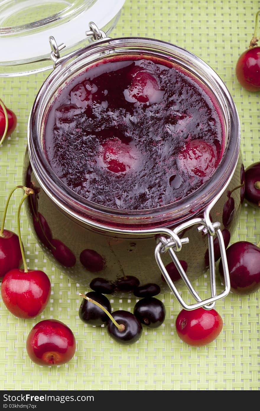 Studio-shot of homemade cherry jam in a glass jar.