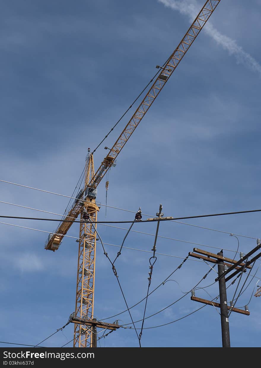 View of a construction crane in downtown of a city. View of a construction crane in downtown of a city