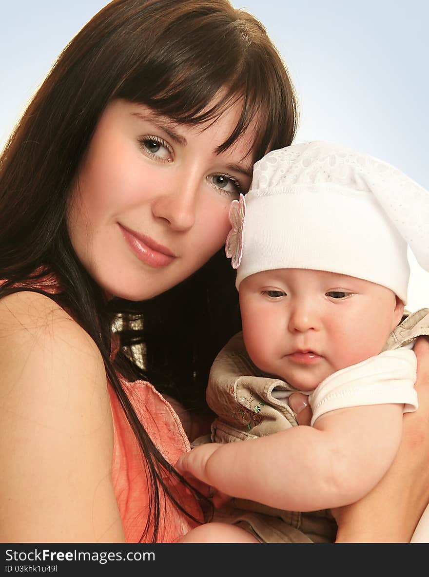 Young mother with baby on blue background