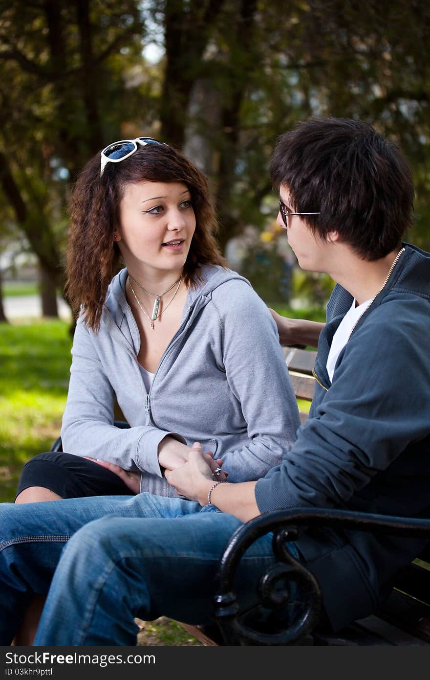 Attractive couple sitting on bench in the park. Attractive couple sitting on bench in the park