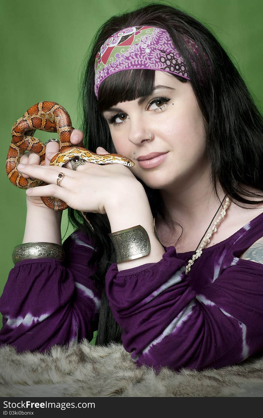 Hippie woman holding tiger corn snake close to face. Hippie woman holding tiger corn snake close to face