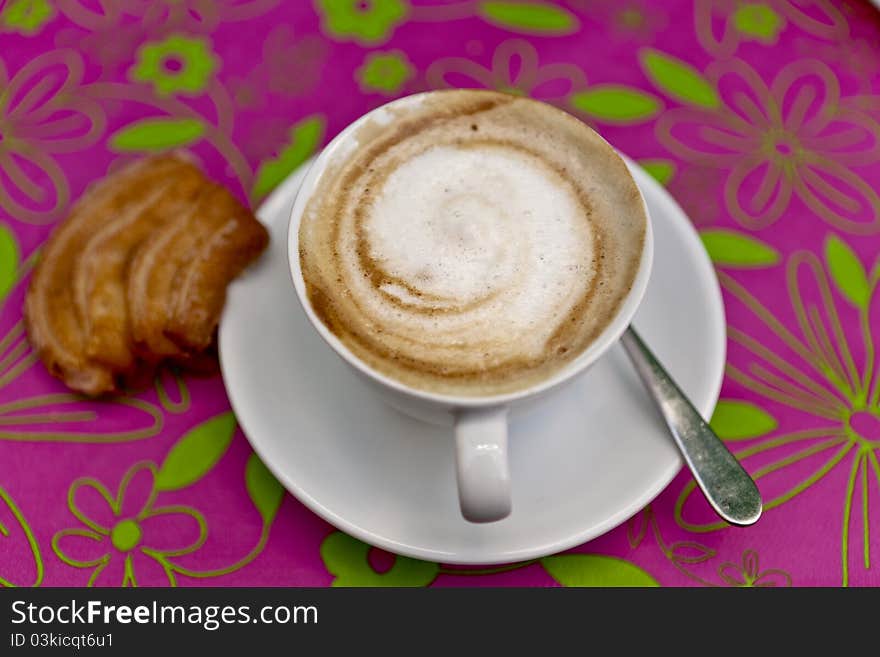 Cappuccino with cookie over coloerful background