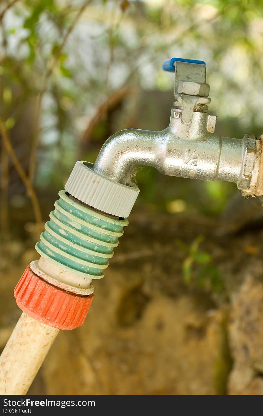 A tap with a hose connector and hose attached to it. A tap with a hose connector and hose attached to it