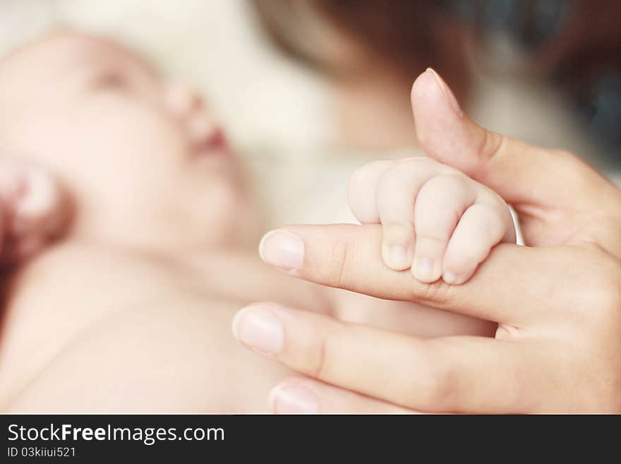 Close-up of baby's hand holding mother's fingerher's. Close-up of baby's hand holding mother's fingerher's