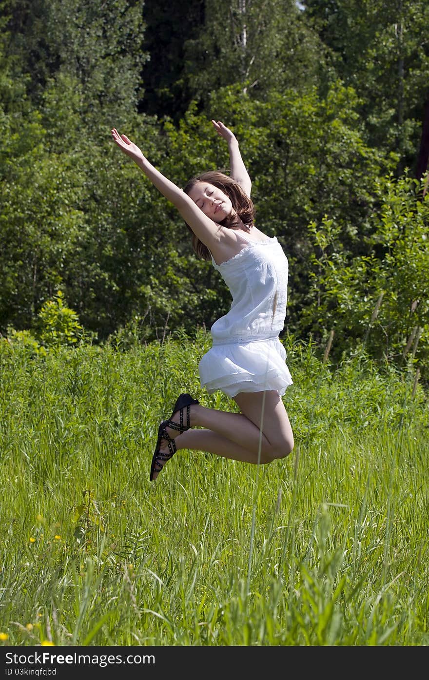 Young happy girl jumping in a meadow. Young happy girl jumping in a meadow