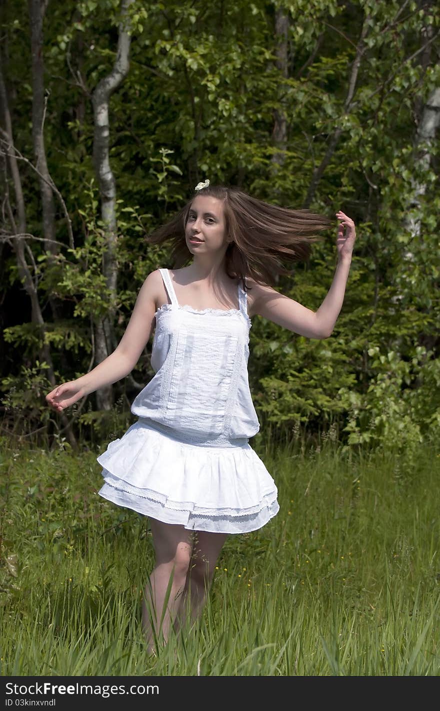 Young girl in a white dress walking in a forest. Young girl in a white dress walking in a forest