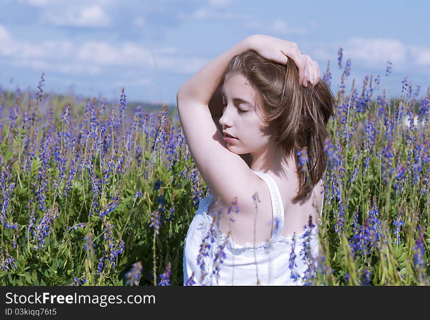 Young dreaming girl walking in a meadow. Young dreaming girl walking in a meadow