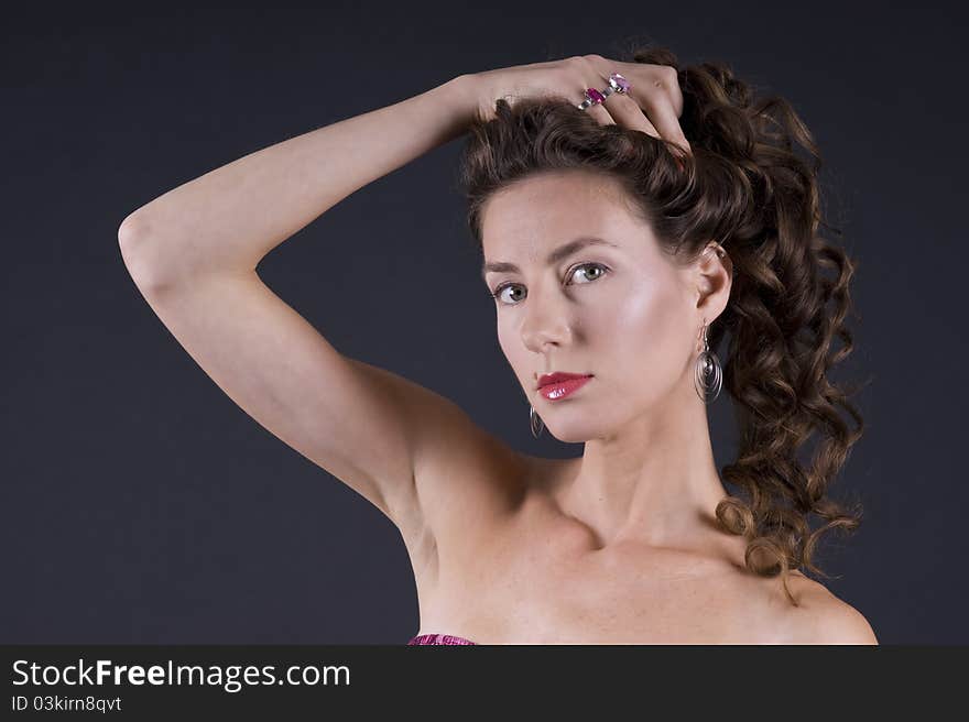 Portrait of a young beautiful woman on a gray background closeup. Portrait of a young beautiful woman on a gray background closeup