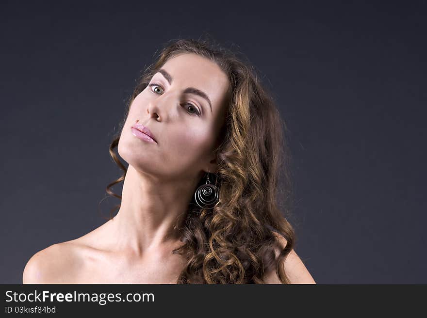 Portrait of a young beautiful woman on a gray background closeup. Portrait of a young beautiful woman on a gray background closeup