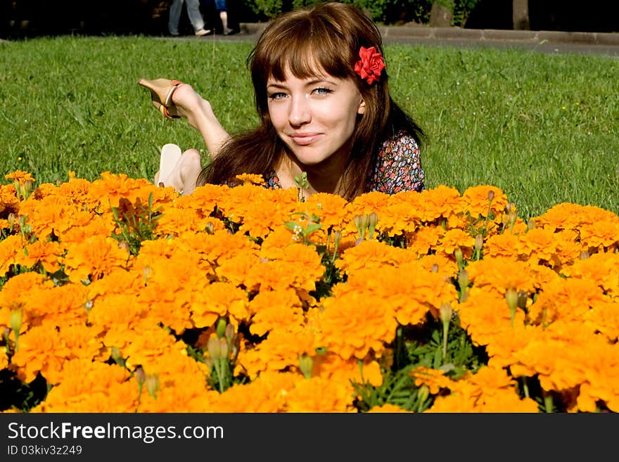 Beautiful girl lying on meadow with flowers