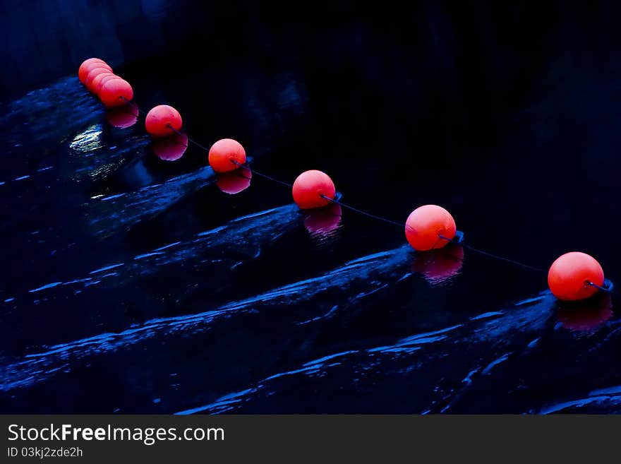 Set of red beacons on deep blue water. Set of red beacons on deep blue water