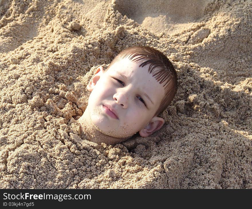 The boy is dig in sand