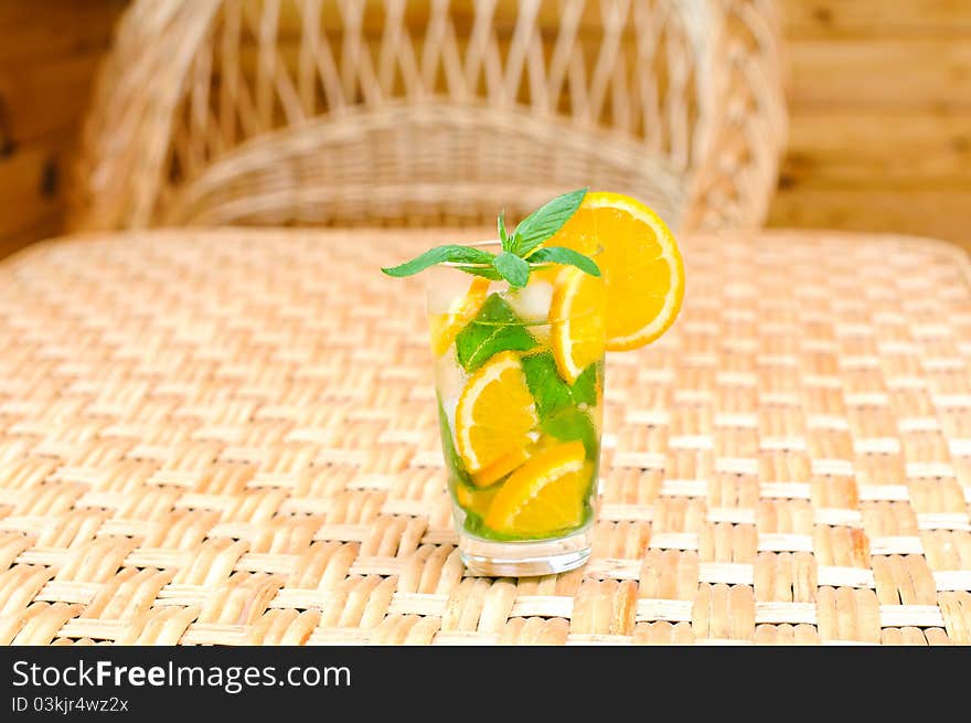 Glass of water with mint leaves and orange on the table. Glass of water with mint leaves and orange on the table