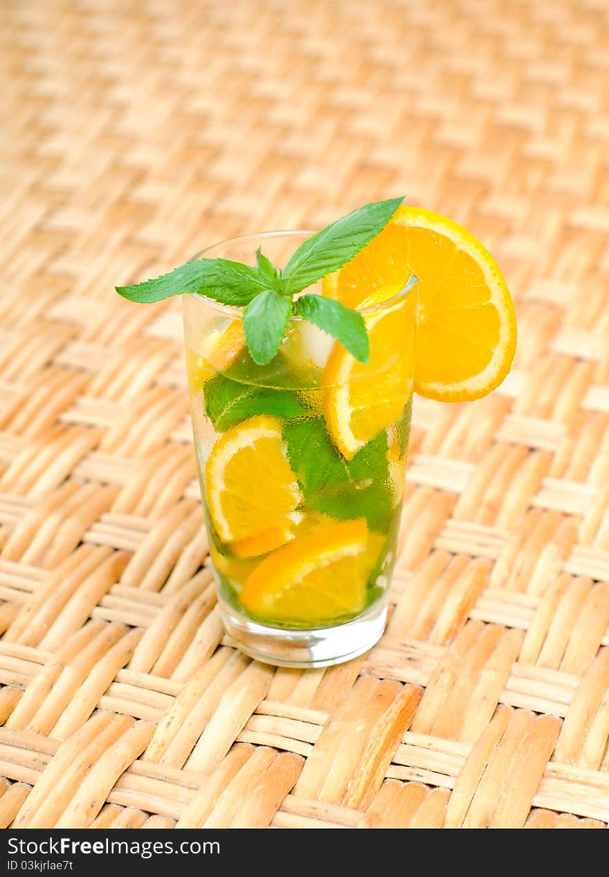 Glass of water with mint leaves and orange on the table. Glass of water with mint leaves and orange on the table